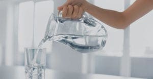 Water in pitcher being poured into a glass